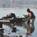Salvadoran Woman Washes Clothes in Flood-Affected Lake