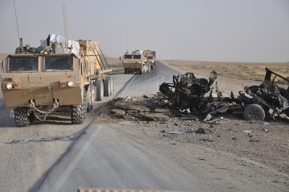 U.S. Military Convoy Bypasses Destroyed Vehicle in Afghanistan