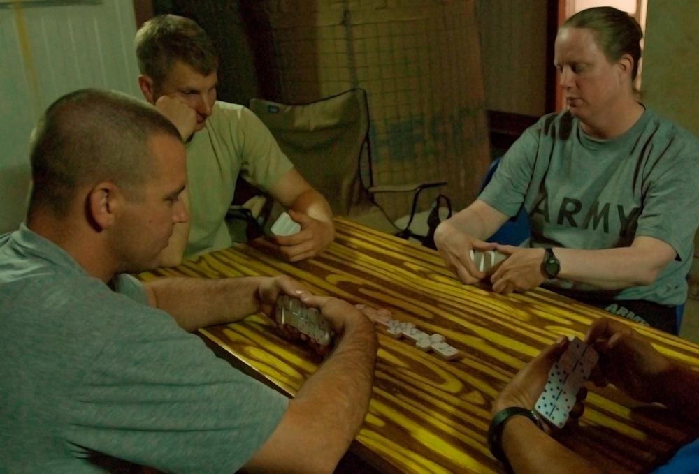 Soldiers and Interpreter Enjoy Downtime with Dominoes Game in Iraq
