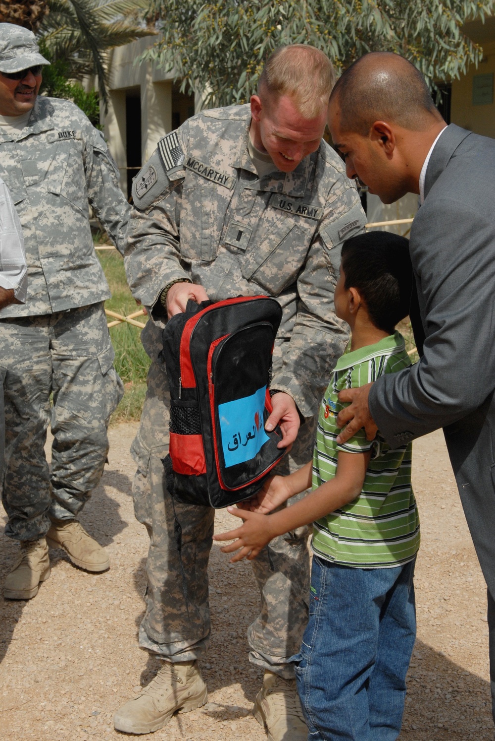 U.S. Soldier Helps Distribute Backpacks to Iraqi Schoolchildren After School Renovation