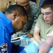 Iraqi Police Officer Practices IV Insertion Under Watchful Eyes of U.S. Army Medics