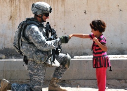Army Soldier Greets Iraqi Girl at Checkpoint