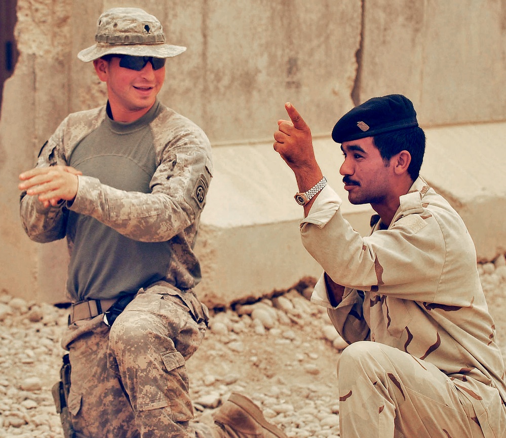 U.S. Army Paratrooper Trains Iraqi Soldier on Squad Formation During Sandstorm