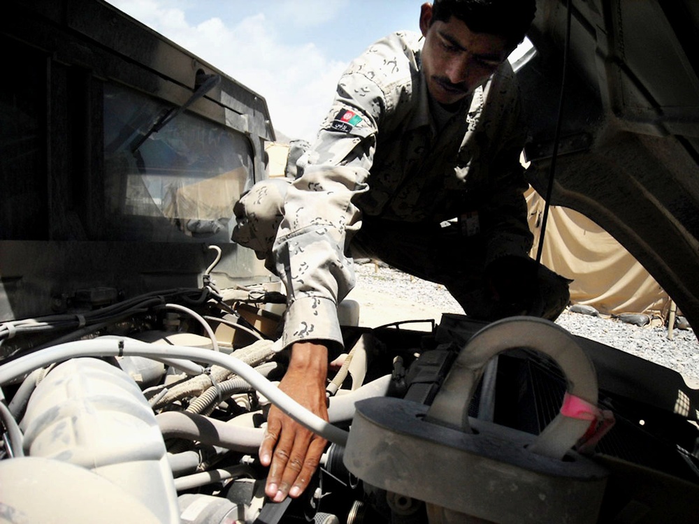 Afghan Border Patrolman Performs Preventive Maintenance on Humvee