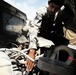 Afghan Border Patrolman Performs Preventive Maintenance on Humvee
