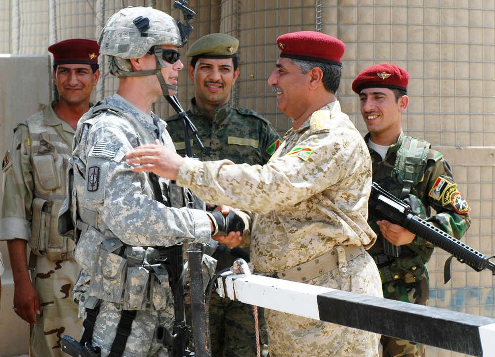 U.S. and Iraqi Army Officers Shake Hands as U.S. Forces Close Gate in Basra