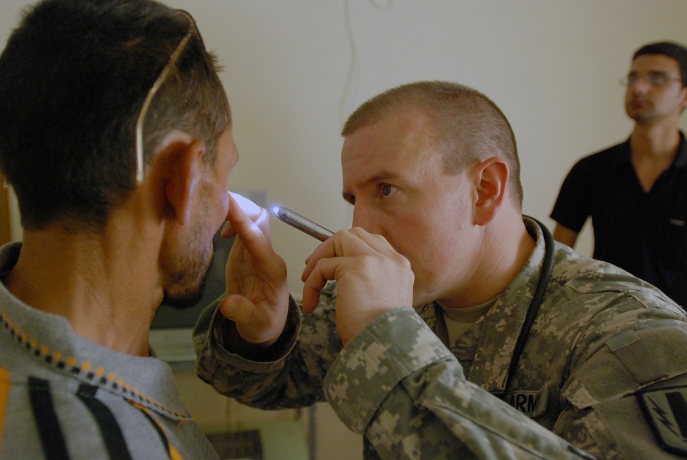 Army Captain Examines Patient's Eye at Medical Engagement in Iraq
