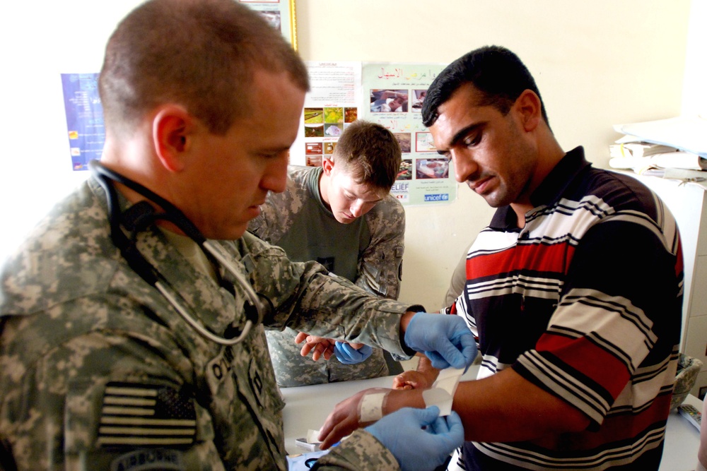 U.S. Soldiers Provide Medical Care to Iraqi Police Recruit