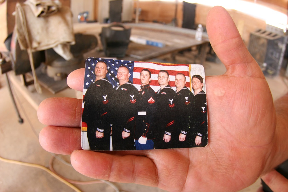 Navy Petty Officer Holds Photo of Family Members Serving in Military