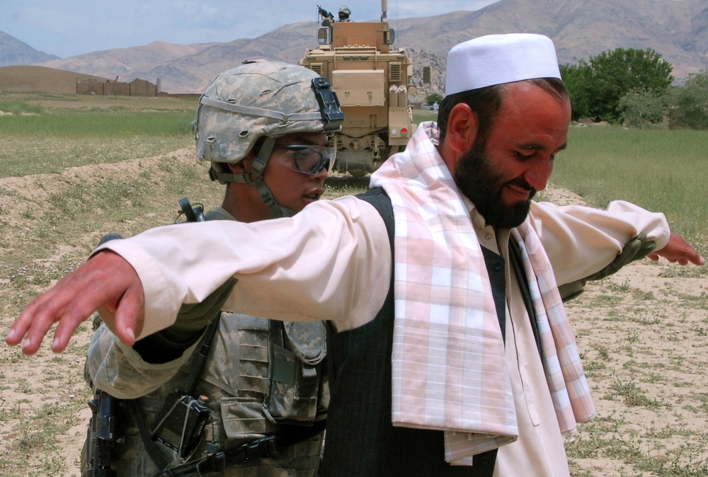 U.S. Soldier Conducts Security Check at Afghan Traffic Checkpoint