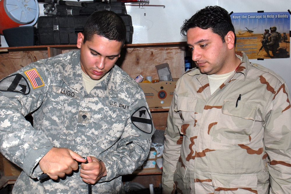 U.S. Soldier Trains Iraqi Counterpart in Fiber Optic Repair