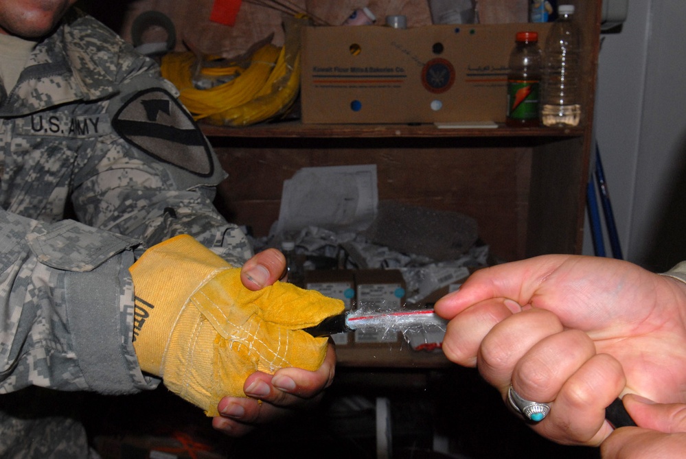 U.S. Soldier Trains Iraqi Counterpart in Fiber Optic Repair