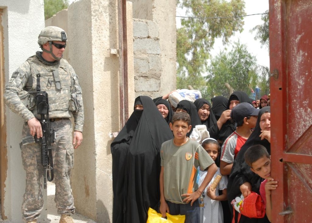 Iraqi Women Receive Food Aid from National Police in Taji