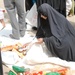 Iraqi Woman Receives Food Aid from National Police in Taji