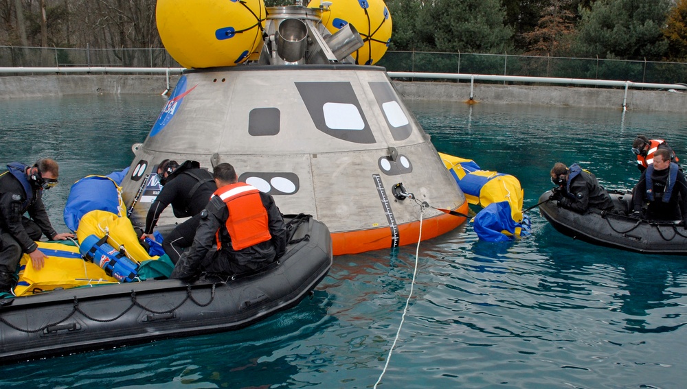 Pararescuemen Deploy Floatation Collar Around Orion Crew Module During Testing