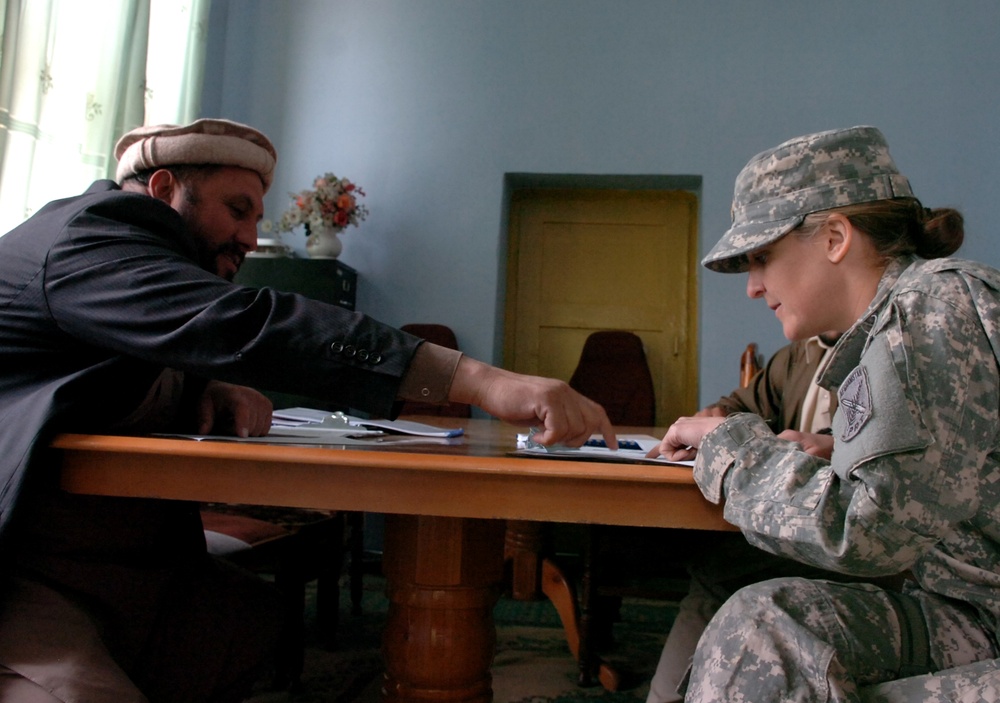 Air Force Officer Reviews Contract Proposal with Afghan Elder