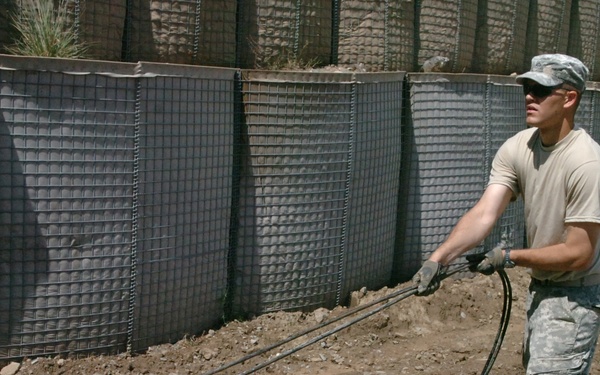 Army Spc. Sudbeck Lays Fiber-Optic Cable at Afghan Base