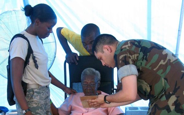 Military Members Provide Eyeglasses to Elderly Woman During Humanitarian Mission