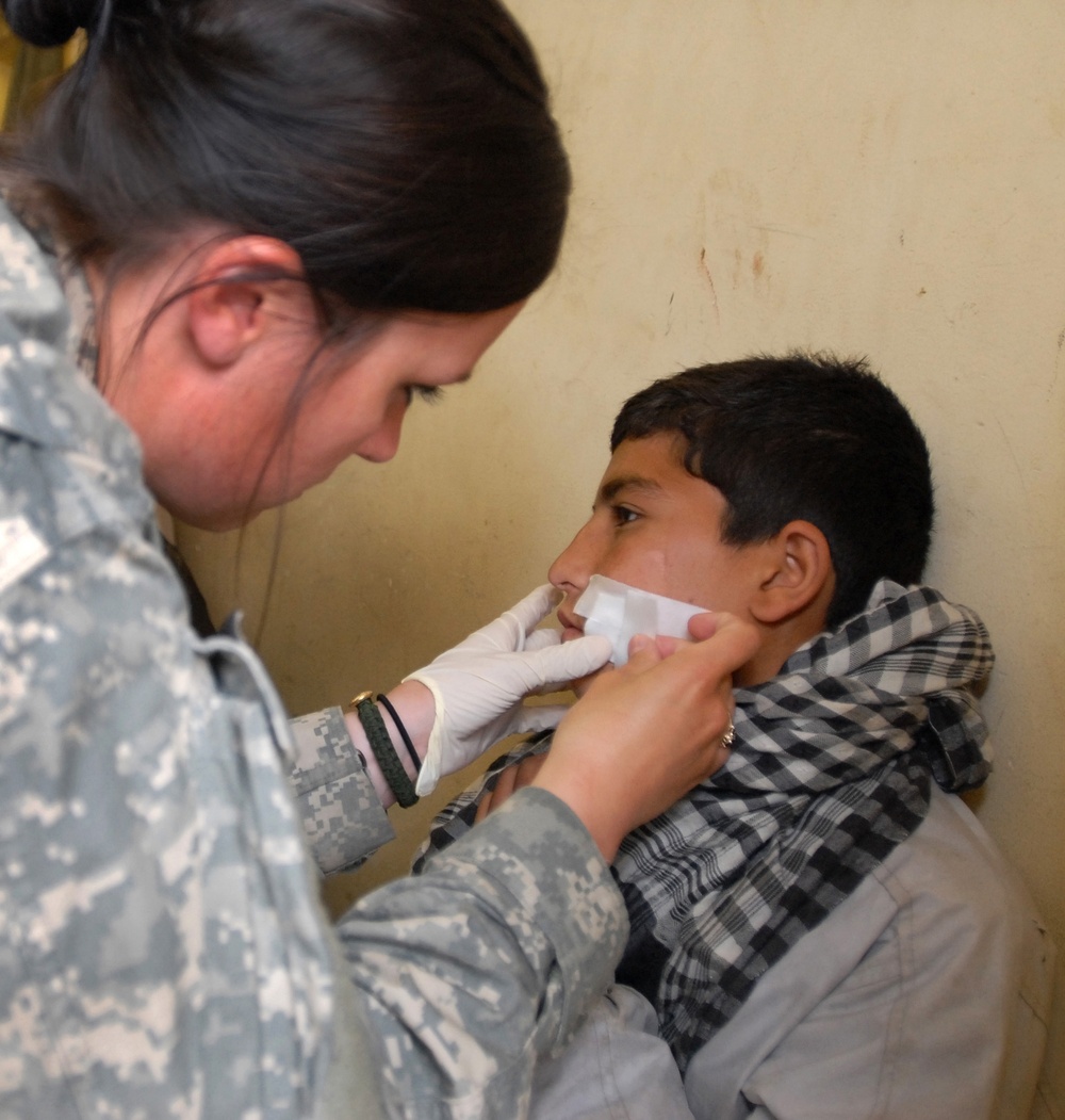 Army Medic Provides Aid to Afghan Boy at Forward Operating Base