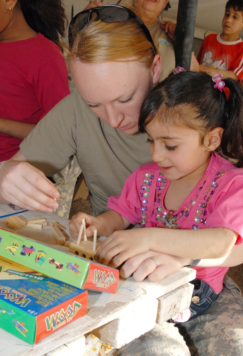Young Iraqi Girl Helps Assemble Model Plane at Camp Victory
