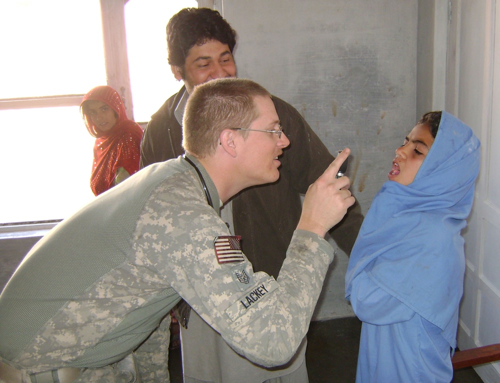 Air Force Medic Provides Care to Afghan Girl at School Clinic