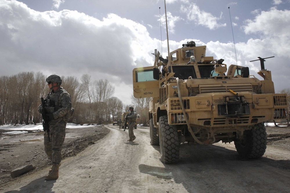 Security Forces Member Scans Area After Convoy Stops to Deliver Aid in Afghanistan