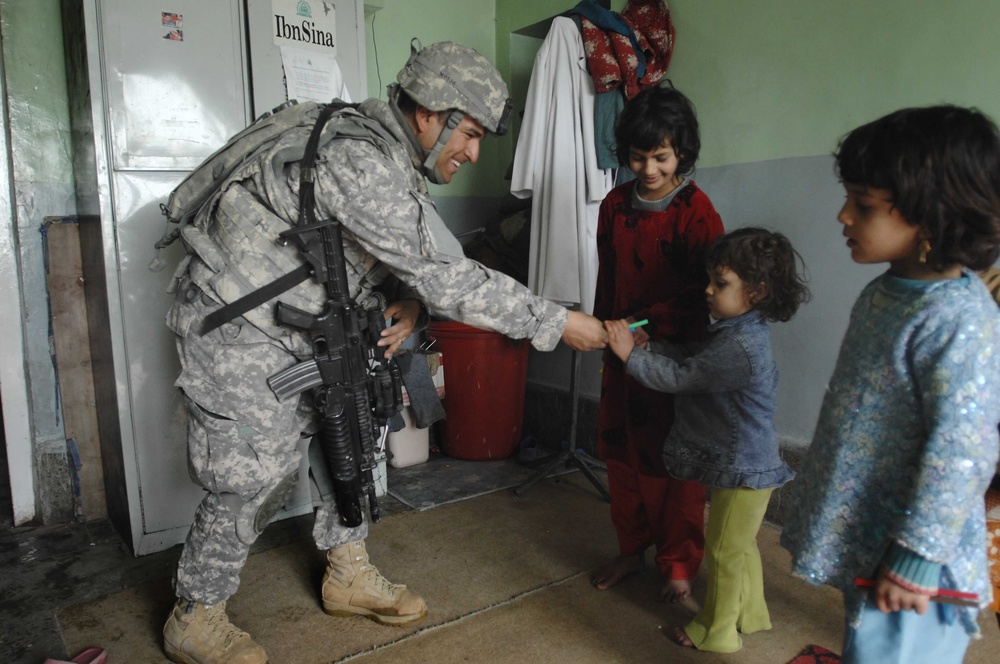Soldier Shares Supplies with Afghan Girl at Provincial Hospital