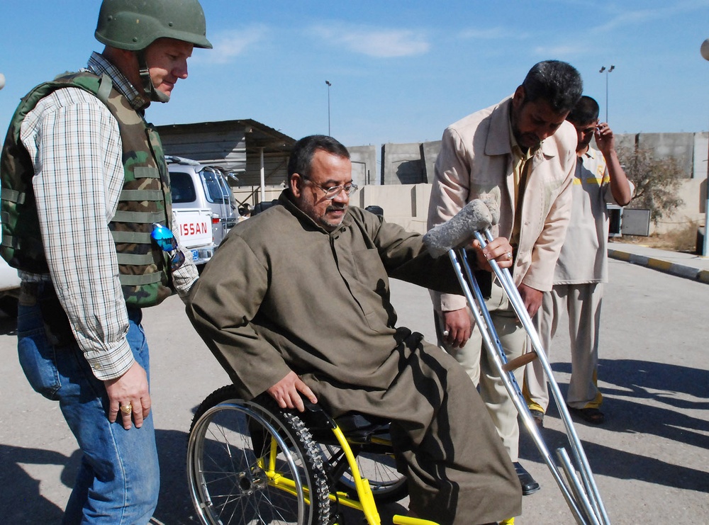 Iraqi Boy Tries Out New Wheelchair at Sadr City Compound