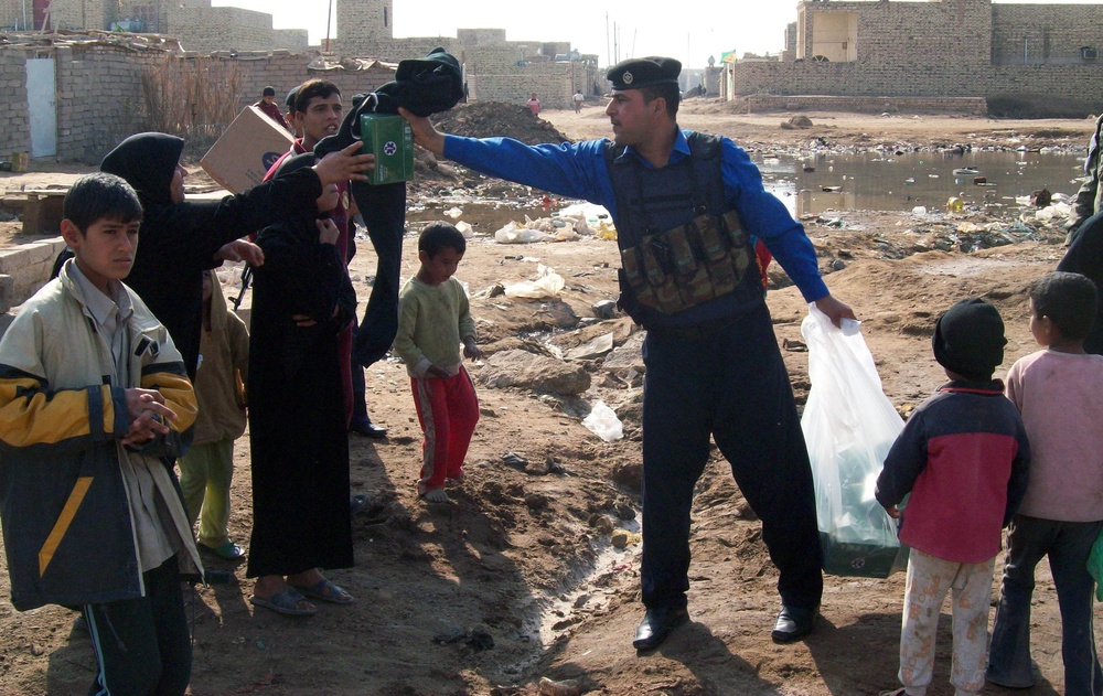 Iraqi Police Officer Distributes Aid to Families in Abu Rummanah