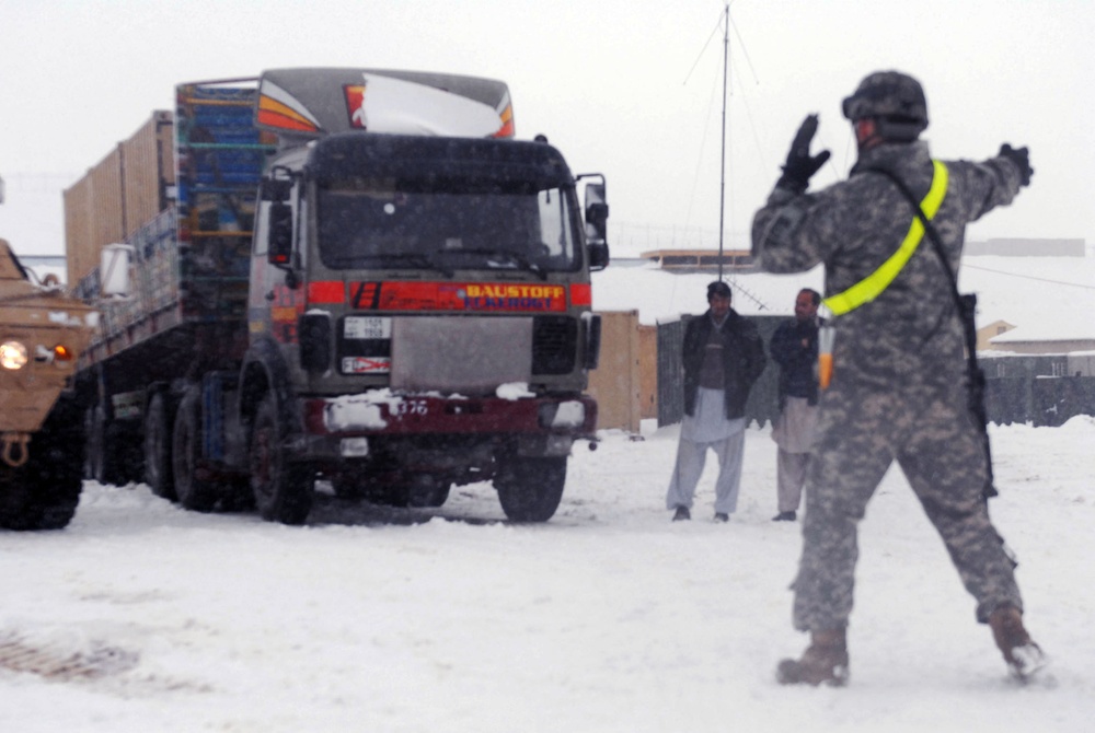 Soldier Guides Truck Loaded with Equipment on Afghan Base