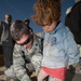 Air Force Doctor Helps Afghan Girl Try on Donated Shoes at Refugee Camp