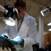Equipment Analyst Inspects Glove Sample from Aircraft Crash Site