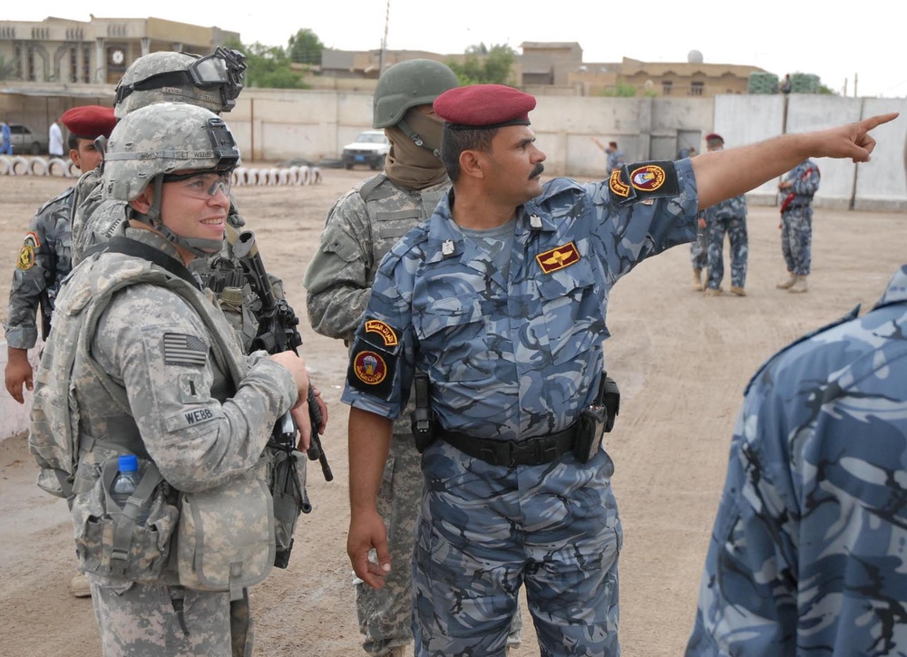 Iraqi Police Officer Explains Security Layout to U.S. Army Lieutenant in Basra