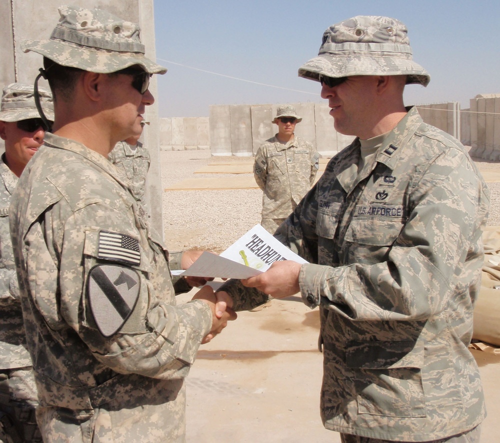 Army Officer Presents Combat Spur to Air Force Counterpart in Iraq