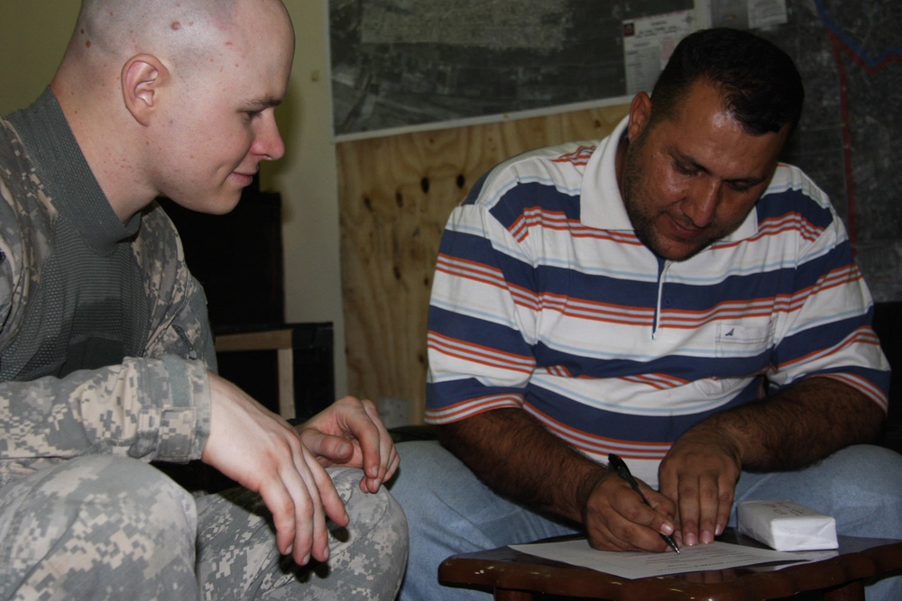 U.S. Army Officer Pays Local Contractor for School Improvements in Iraq