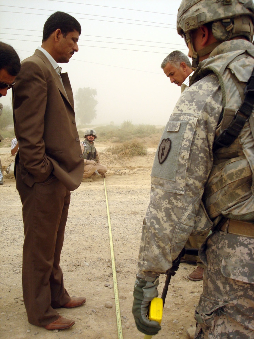 U.S. Soldier Helps Measure Road for Paving in Iraq