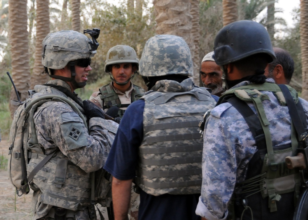 U.S. Soldier Accepts Gift of Dates from Iraqi Farmer During Joint Patrol