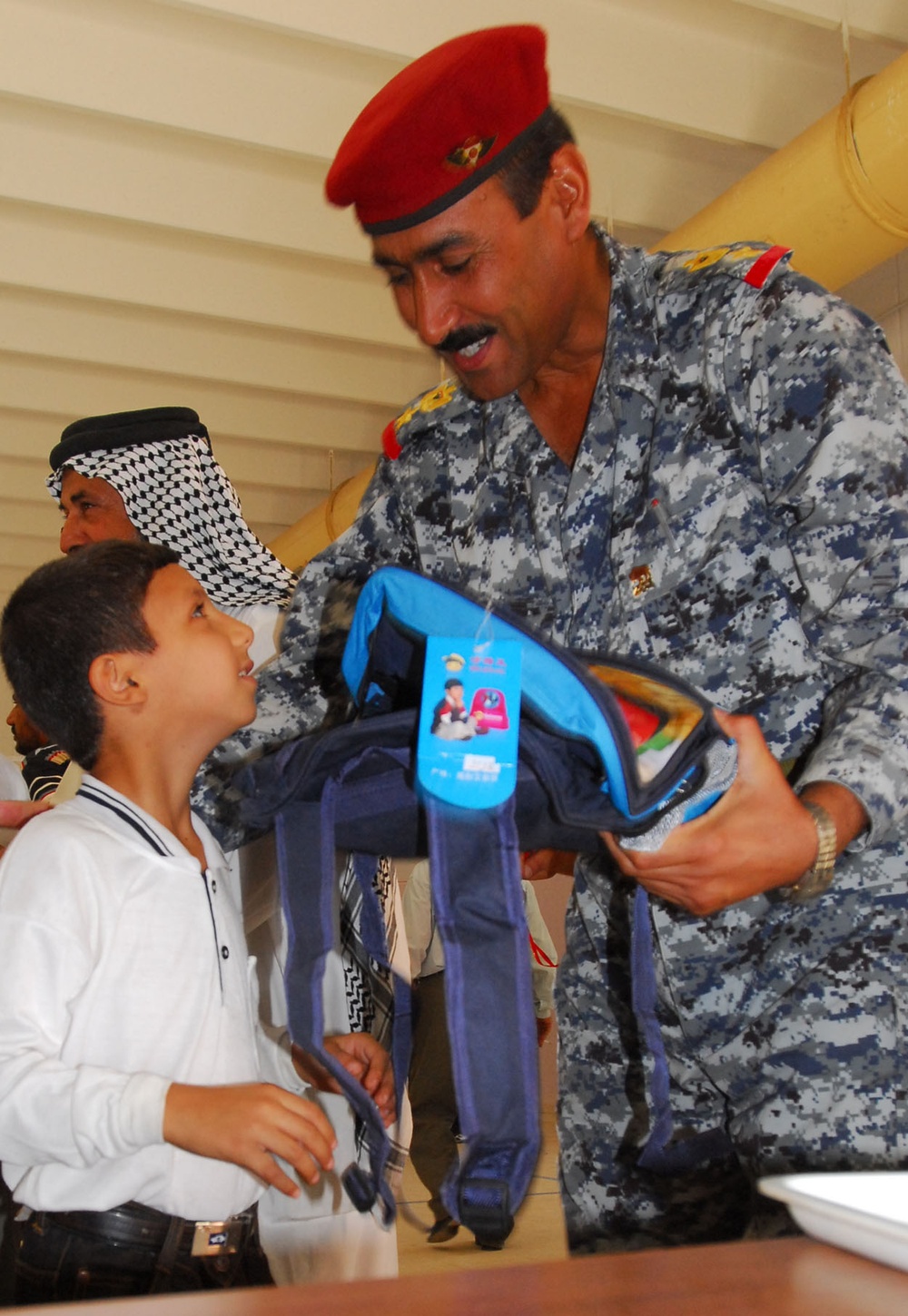 Iraqi National Police Officer Distributes School Supplies to Children in Baghdad