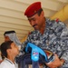Iraqi National Police Officer Distributes School Supplies to Children in Baghdad