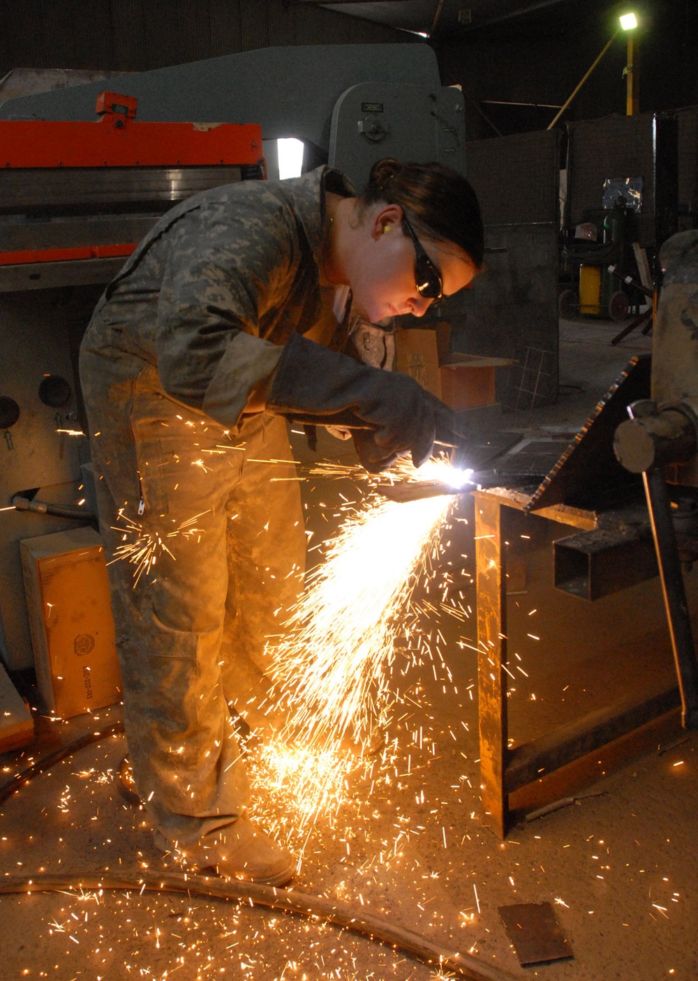 Army Spc. Larissa Reed Cuts Steel Plate at Forward Operating Base Falcon