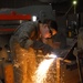 Army Spc. Larissa Reed Cuts Steel Plate at Forward Operating Base Falcon