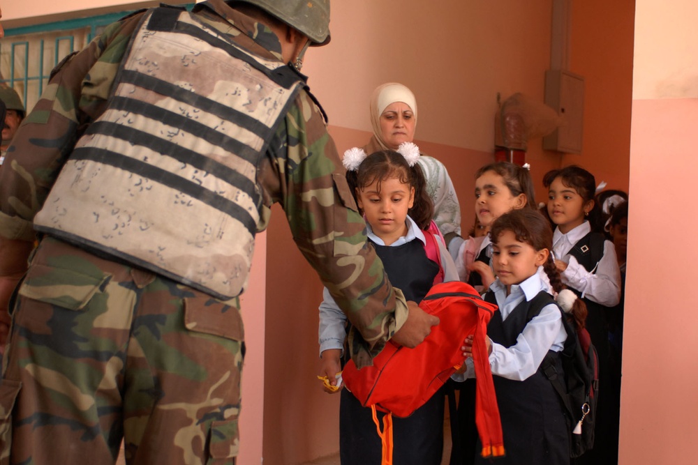 Iraqi Soldier Assists Student at Baghdad School