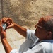 Iraqi Citizen Reads from Tip Hotline Card as Soldiers Provide Security for Returning Families