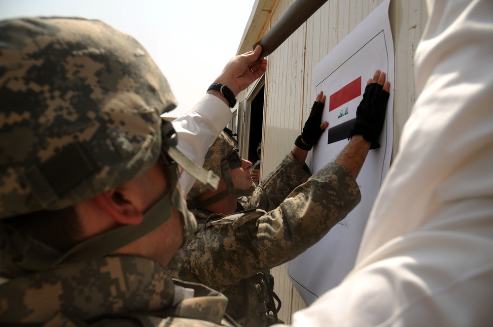 Army NCO Hangs Sign at New Iraqi Assistance Center in Baghdad
