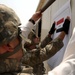 Army NCO Hangs Sign at New Iraqi Assistance Center in Baghdad