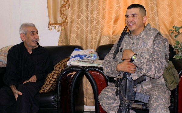 U.S. Soldier Interacts with Iraqi Civilian During Household Assessment