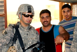 Army Staff Sgt. Interacts with Iraqi Civilians During Household Assessment