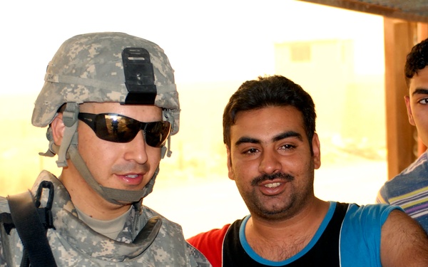 Army Staff Sgt. Interacts with Iraqi Civilians During Household Assessment