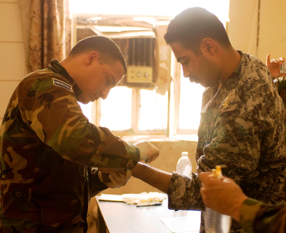 Salvadoran Officer Provides Medical Care to Iraqi Policeman in Kut