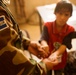 Salvadoran Officer Examines Iraqi Boy's Hands During Medical Mission in Kut
